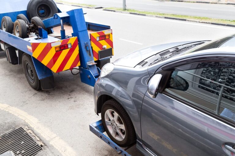 tow truck towing a broken down car on the street.jpg